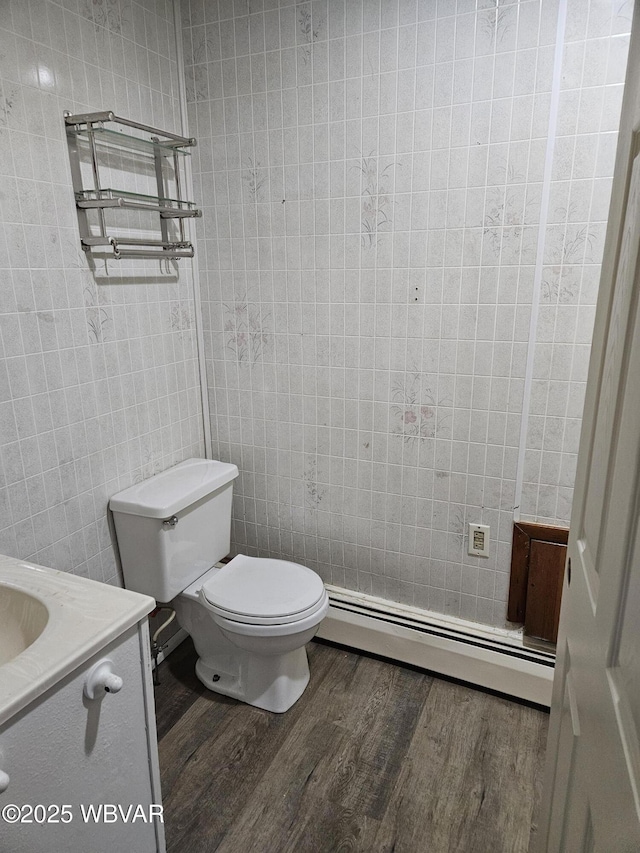 bathroom featuring baseboard heating, toilet, vanity, and hardwood / wood-style flooring