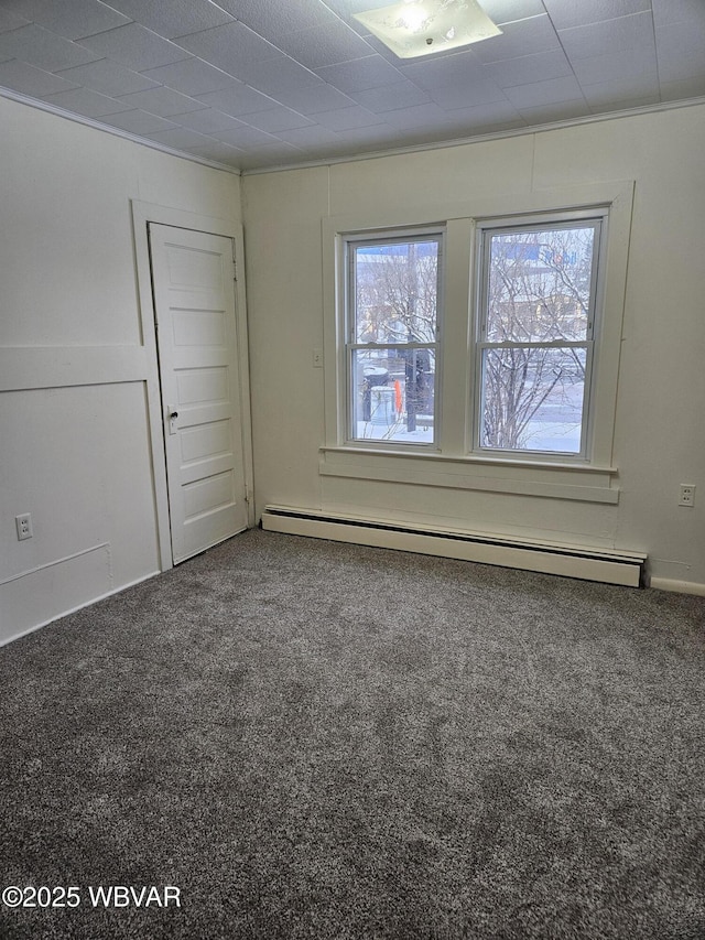 spare room featuring carpet flooring, baseboard heating, and ornamental molding