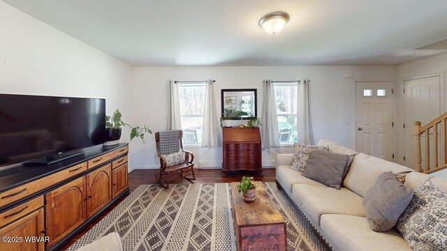 living area featuring dark wood finished floors, baseboards, stairs, and a baseboard radiator