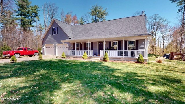 view of front facade with a porch, a garage, driveway, roof with shingles, and a front yard