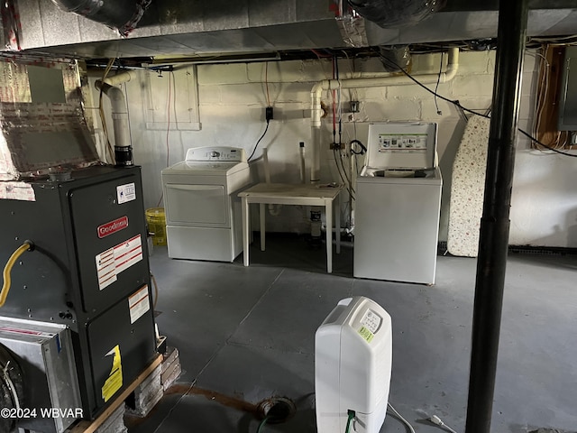 basement featuring heating unit and washing machine and clothes dryer