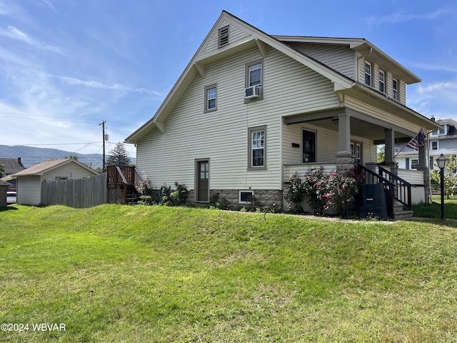 back of house featuring a lawn and covered porch