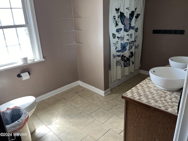 bathroom featuring a shower with shower curtain, vanity, toilet, and tile patterned floors