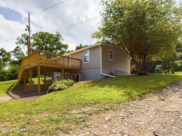 back of house with a lawn and a deck