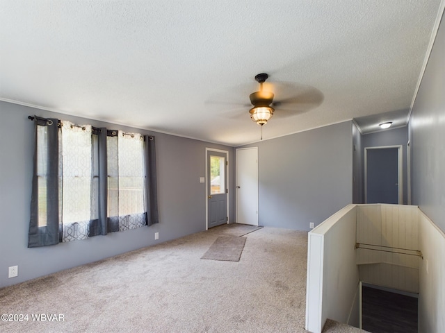 foyer with carpet flooring, ceiling fan, and a textured ceiling