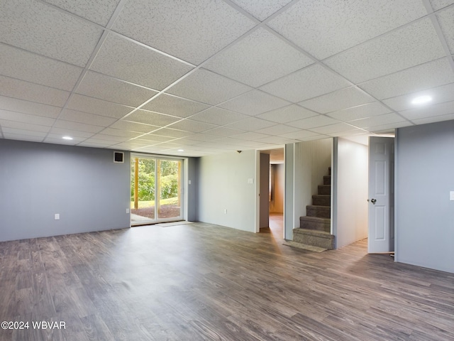 interior space with a drop ceiling and wood-type flooring