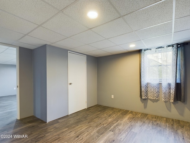 interior space with a paneled ceiling and wood-type flooring