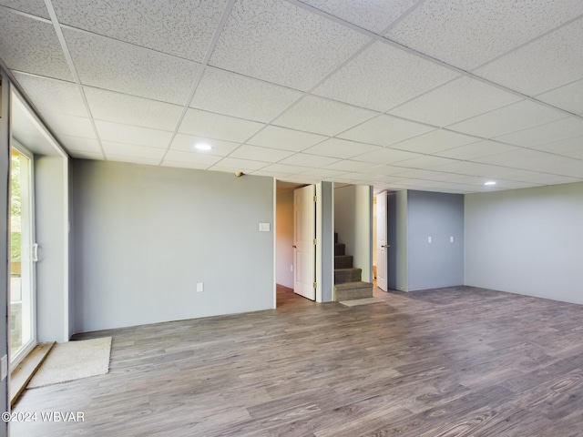 unfurnished room with wood-type flooring and a paneled ceiling