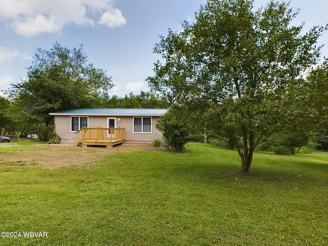 view of front facade with a front yard and a deck