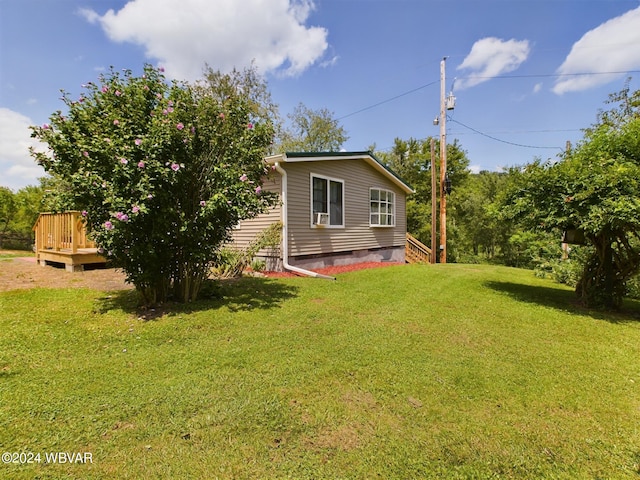 view of side of property featuring a wooden deck and a yard