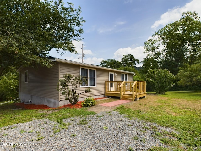 view of front of property with a wooden deck and a front lawn