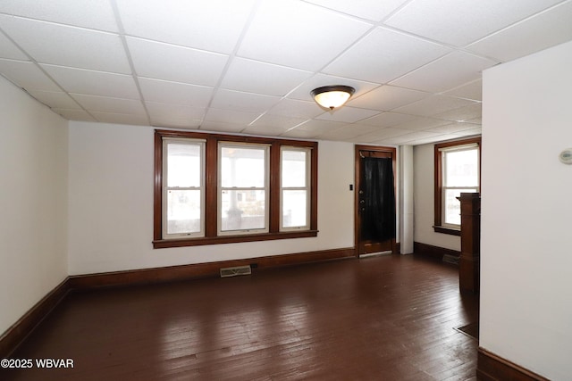 unfurnished room featuring a paneled ceiling and dark hardwood / wood-style flooring