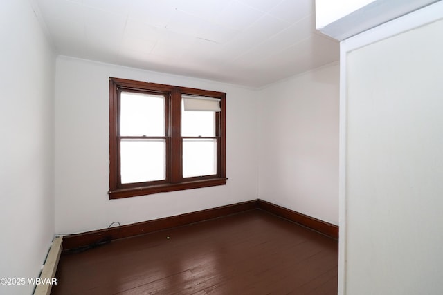 unfurnished room with baseboard heating and dark hardwood / wood-style floors