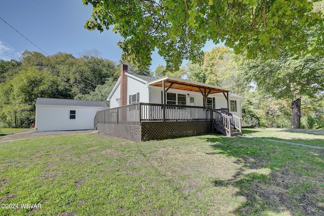 view of front of property featuring a front yard, an outdoor structure, and a wooden deck