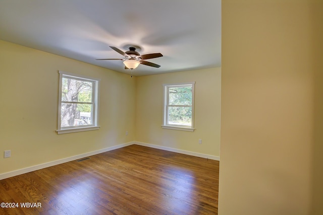 spare room featuring wood-type flooring, ceiling fan, and a healthy amount of sunlight