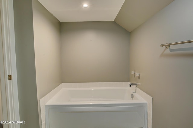 bathroom featuring a bathing tub and lofted ceiling