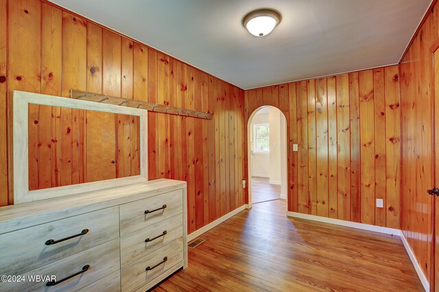 interior space featuring wooden walls and light hardwood / wood-style flooring