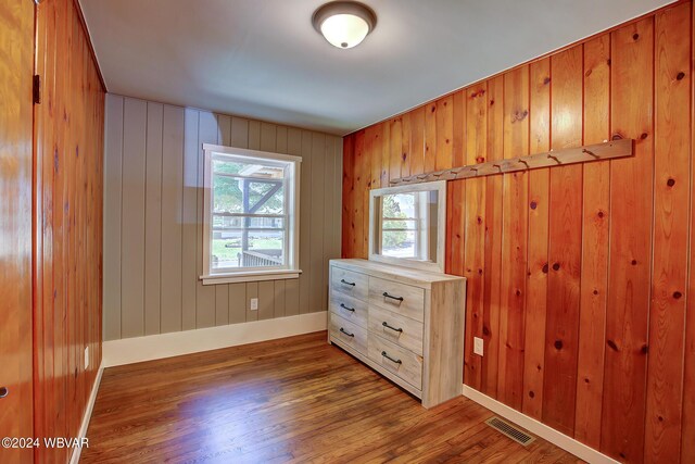 unfurnished bedroom featuring hardwood / wood-style floors and wood walls