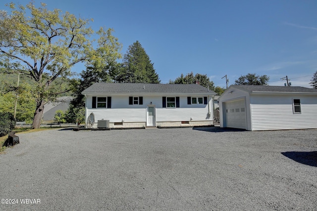 view of front of property featuring cooling unit, a garage, and an outdoor structure