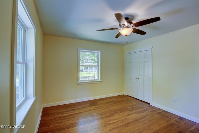 unfurnished bedroom featuring ceiling fan, wood-type flooring, and a closet