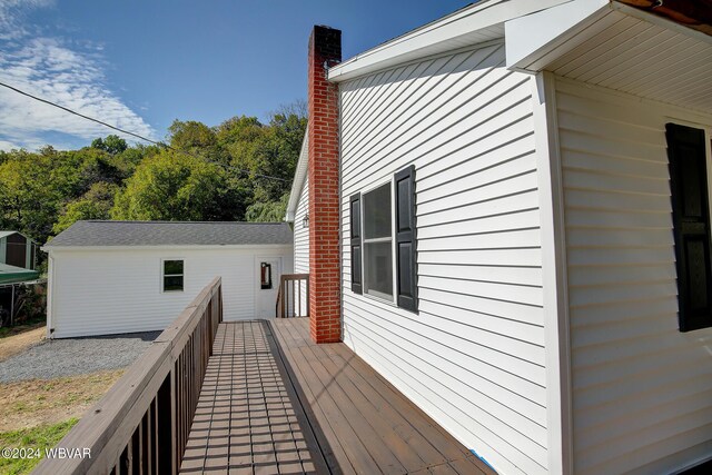 view of home's exterior with a wooden deck and an outbuilding