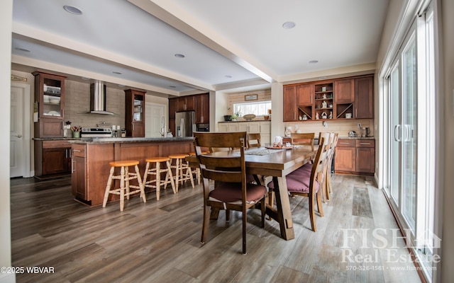 dining room featuring dark hardwood / wood-style flooring and beam ceiling