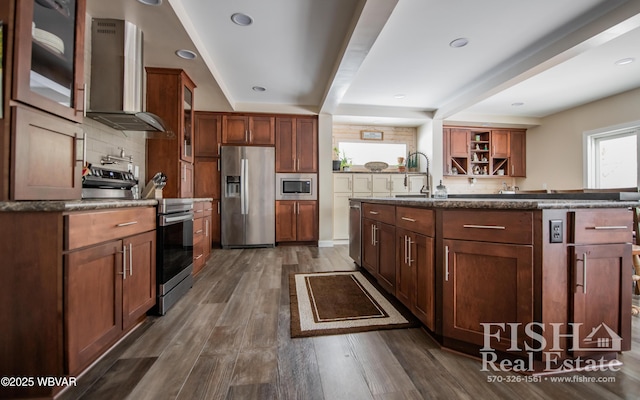 kitchen with appliances with stainless steel finishes, tasteful backsplash, sink, dark wood-type flooring, and wall chimney exhaust hood