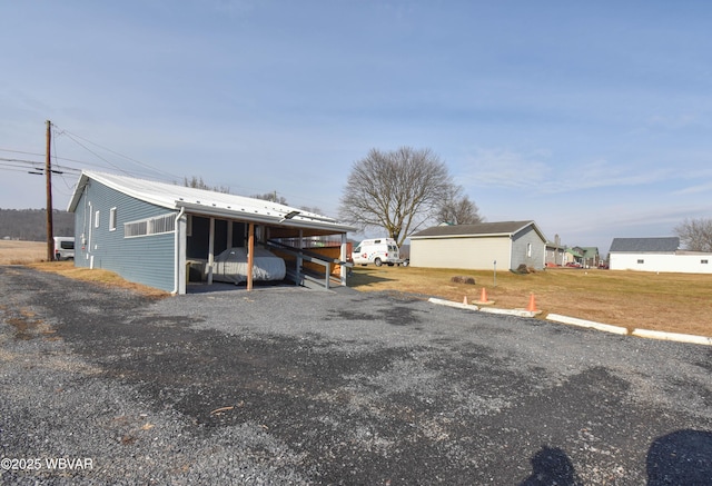 exterior space featuring an outdoor structure, a carport, and a pole building