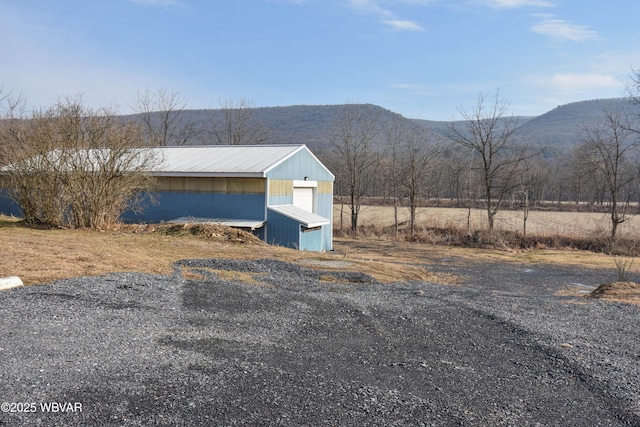 view of front of home with a mountain view and an outbuilding