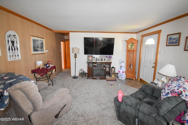 living area with carpet flooring, wooden walls, a fireplace, and crown molding