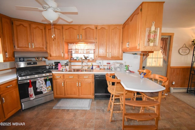 kitchen featuring a wainscoted wall, black dishwasher, a wealth of natural light, stainless steel gas stove, and a sink