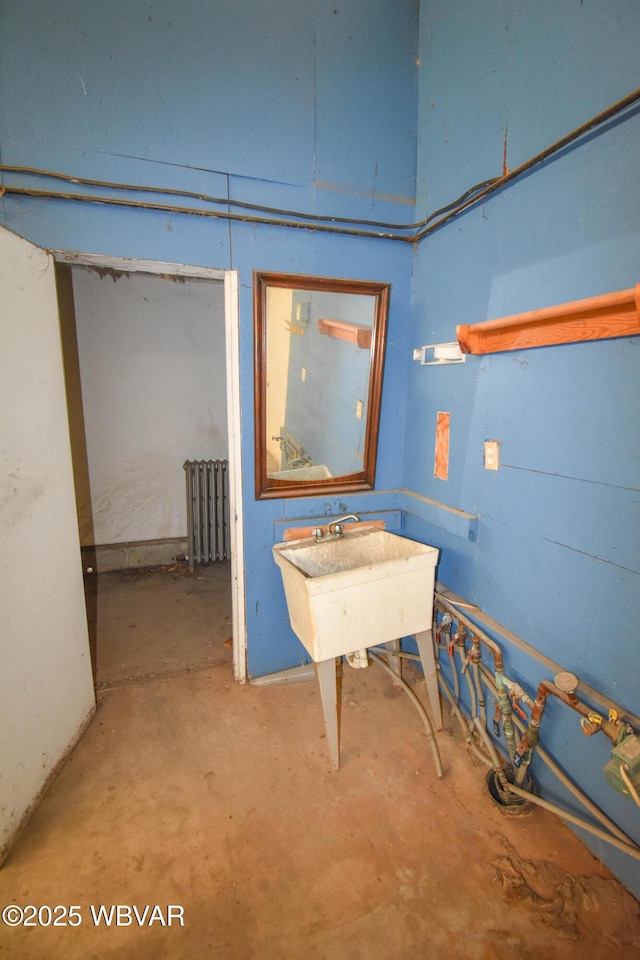 below grade area featuring radiator and a sink