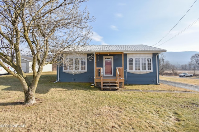 bungalow-style home with a front yard and metal roof