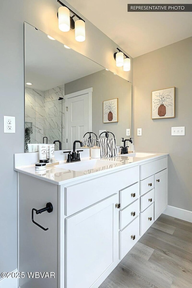 2287 Warrensville Rd, Montoursville, PA 17754 - bathroom featuring a marble finish shower, double vanity, wood finished floors, and baseboards