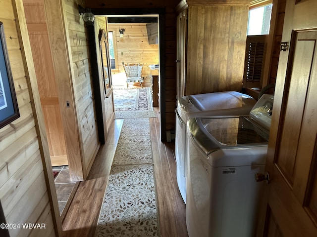 washroom with wooden walls and washer and dryer