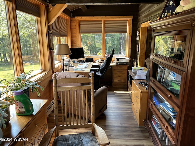 office space with beamed ceiling, plenty of natural light, log walls, and dark hardwood / wood-style floors