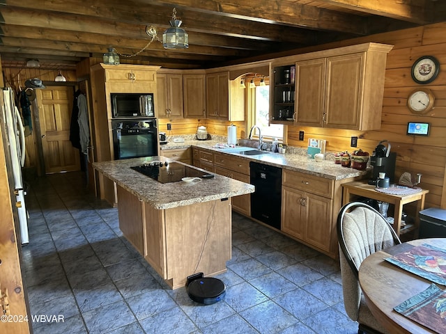 kitchen featuring light stone countertops, sink, black appliances, beam ceiling, and wood walls