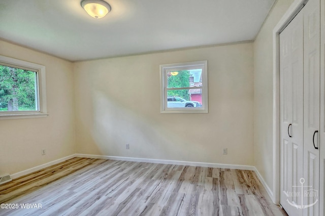 294 Park Ave, Lock Haven, PA 17745 - unfurnished bedroom featuring multiple windows, light wood-style flooring, and baseboards