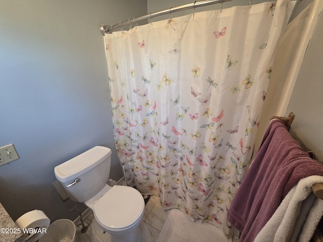 bathroom featuring a shower with shower curtain and toilet