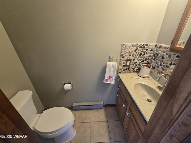 bathroom with tile patterned flooring, baseboards, toilet, vanity, and a baseboard radiator