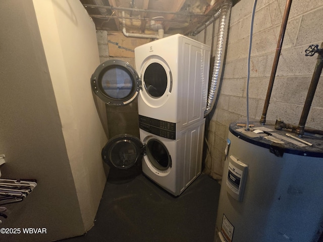 laundry area featuring laundry area, water heater, and stacked washing maching and dryer