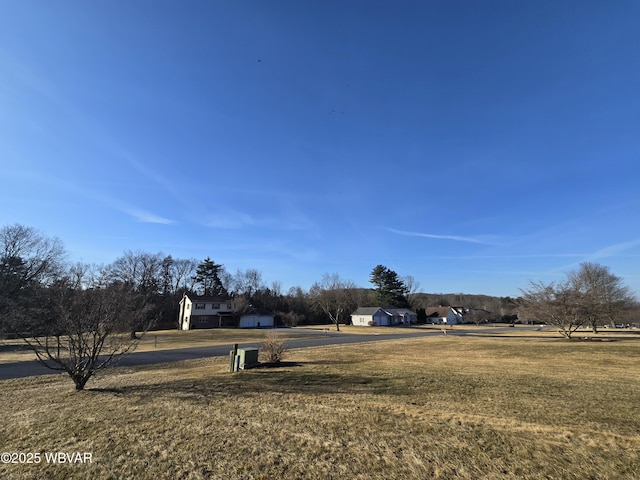 view of home's community featuring a lawn and driveway