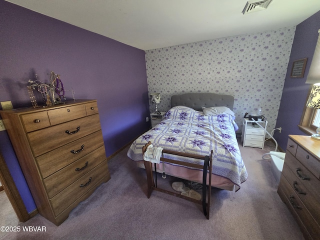 bedroom featuring dark colored carpet, visible vents, and wallpapered walls