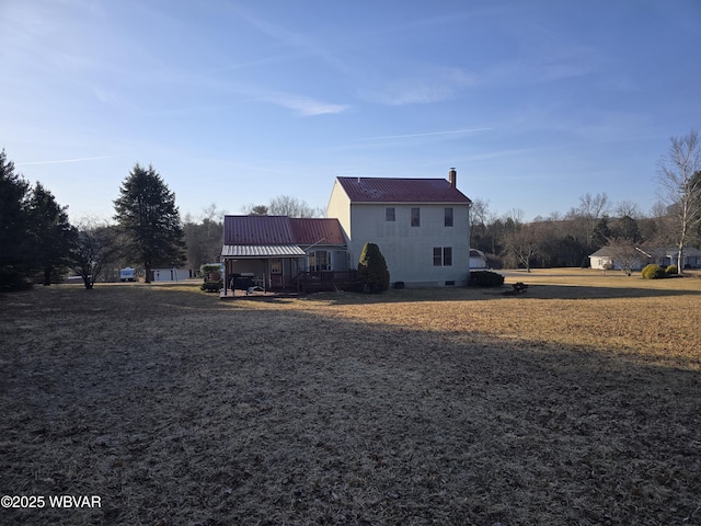 back of property with a chimney and metal roof