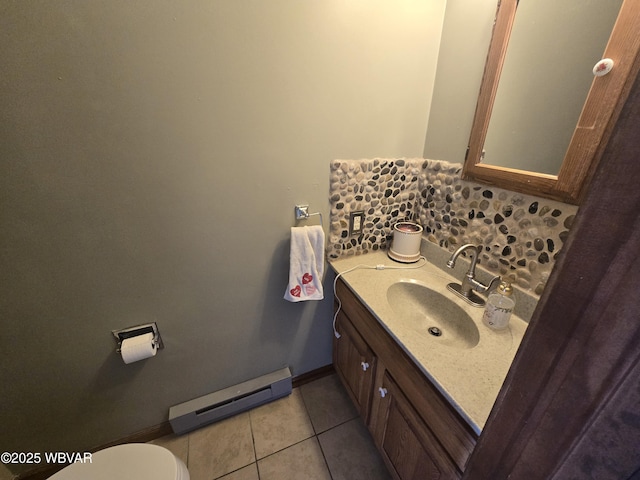 bathroom with tile patterned floors, toilet, a baseboard radiator, baseboards, and vanity