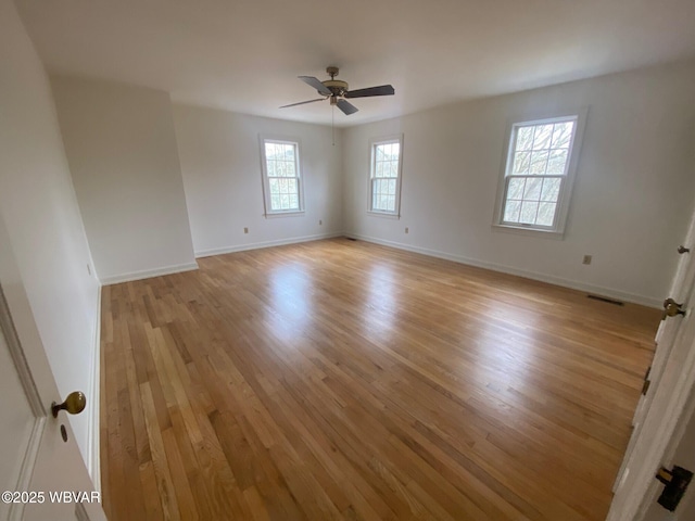 unfurnished room with light wood-style flooring, visible vents, baseboards, and ceiling fan