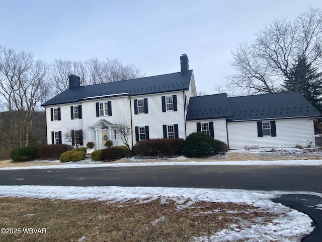 view of front of home featuring metal roof and a chimney