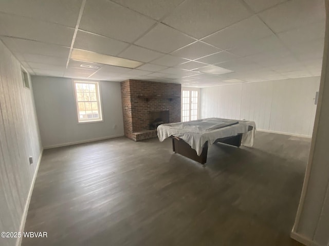 playroom featuring a paneled ceiling, pool table, wood finished floors, baseboards, and a brick fireplace