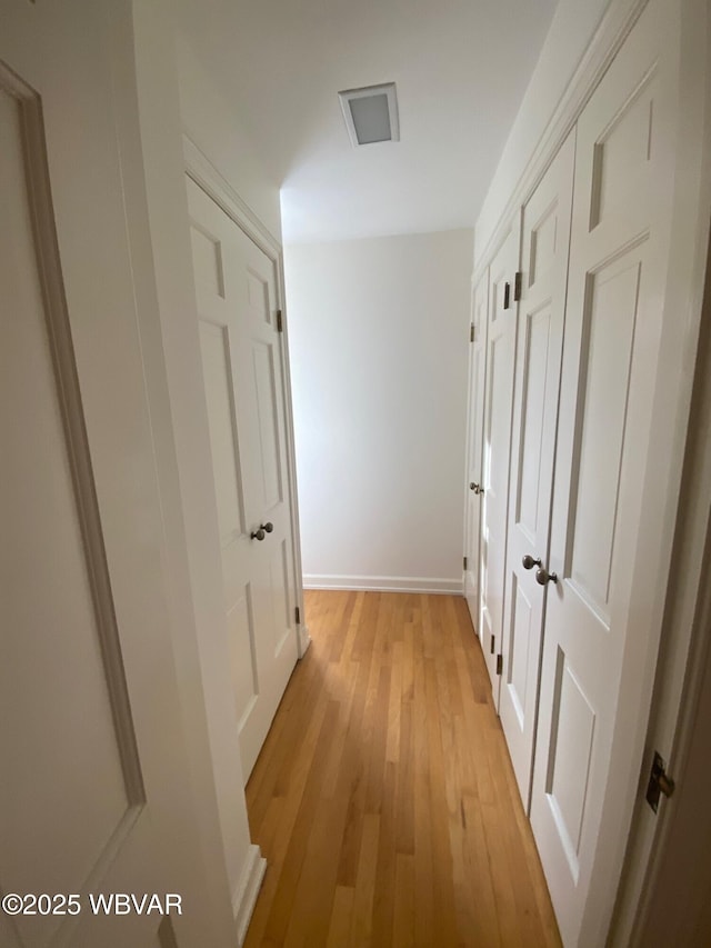 hallway with light wood-style flooring and baseboards