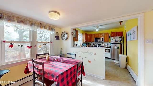 dining space featuring baseboard heating and ceiling fan